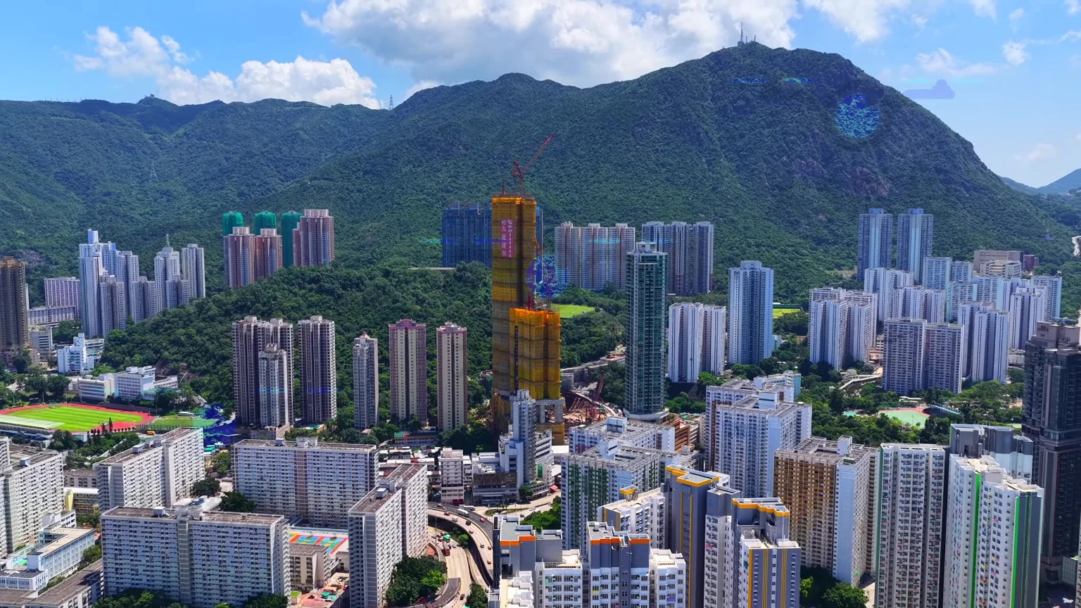 牛池灣航拍實景，可見興建中的住宅大樓及背後山景